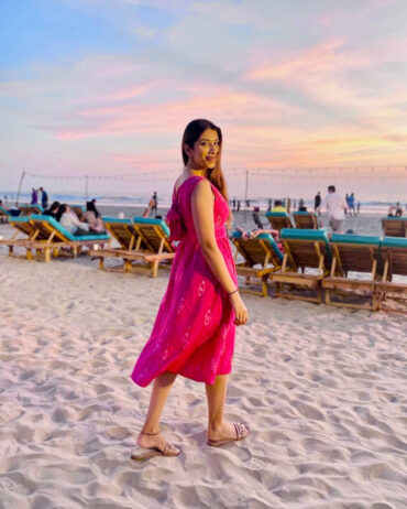 Side view of Strawberry Pink Ikat cotton midi beach dress with oversized bow tie, V-back neckline, and handloom pattern; Abravi sustainable fashion.