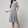 Indian boho model wearing calf length coin grey Ikat wrap dress with adjustable tie and two pockets.