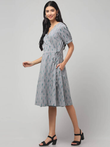 Indian boho model wearing calf length coin grey Ikat wrap dress with adjustable tie and two pockets.