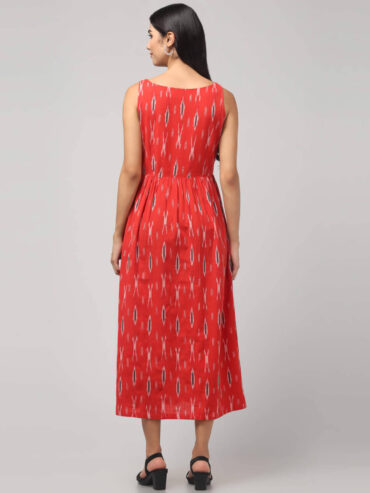 Indian woman wearing coral red Ikat handloom A-line maxi dress made with 100% cotton with 2 functional pockets.