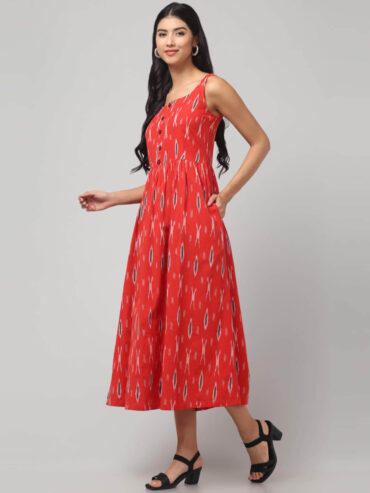 Side view of coral red sustainable handloom cotton Ikat dress with buttoned front and 2 pockets.