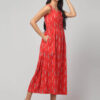 Indian model wearing coral red sleeveless Ikat maxi dress with flare and 2 pockets.