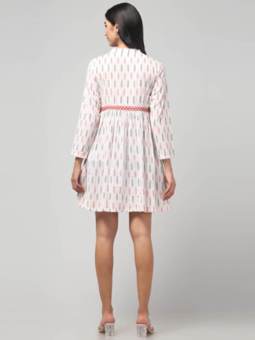 Detailed back shot of Ikat handloom pattern and red zigzag embroidery on the waist of Abravi's cotton mini dress
