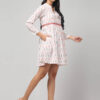 Side view of white Ikat handloom cotton dress featuring red zigzag waist embroidery and long sleeves.