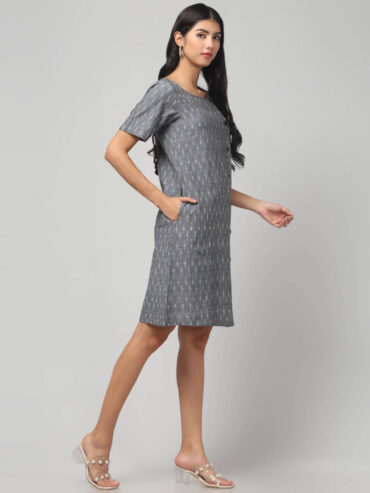 Indian female model wearing Pochampally handloom Ikat pure cotton knee length shift dress with two pockets and short sleeves.