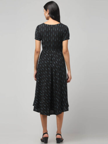 Local Indian model wearing charcoal black Ikat cotton dress for women and teenagers girls featuring puff sleeves and airy flared fit