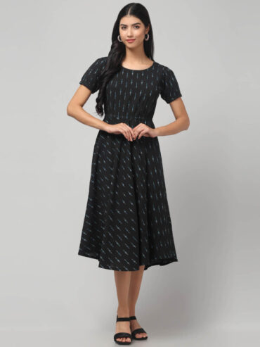 Indian female model showcasing swadeshi handmade charcoal black Ikath cotton fit and flare midi dress for local bharat