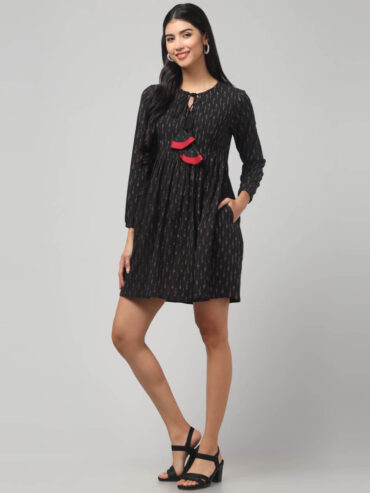 Indian women's Black Ikat Cotton dress featuring red tassels, gathered waist, and roomy pockets.