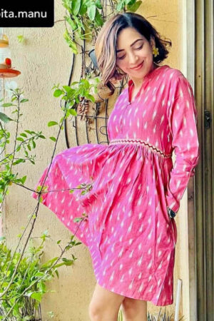 Women wearing a pink Ikat Handloom cotton fir and flare dress with full sleeves, collared keyhole neckline, and two deep side pockets, photographed outdoor in natural lights.