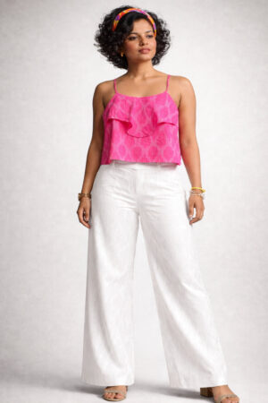 Indian female model wearing a pink Ikat Handloom Cotton crop top with white pants in a minimalist studio setting.
